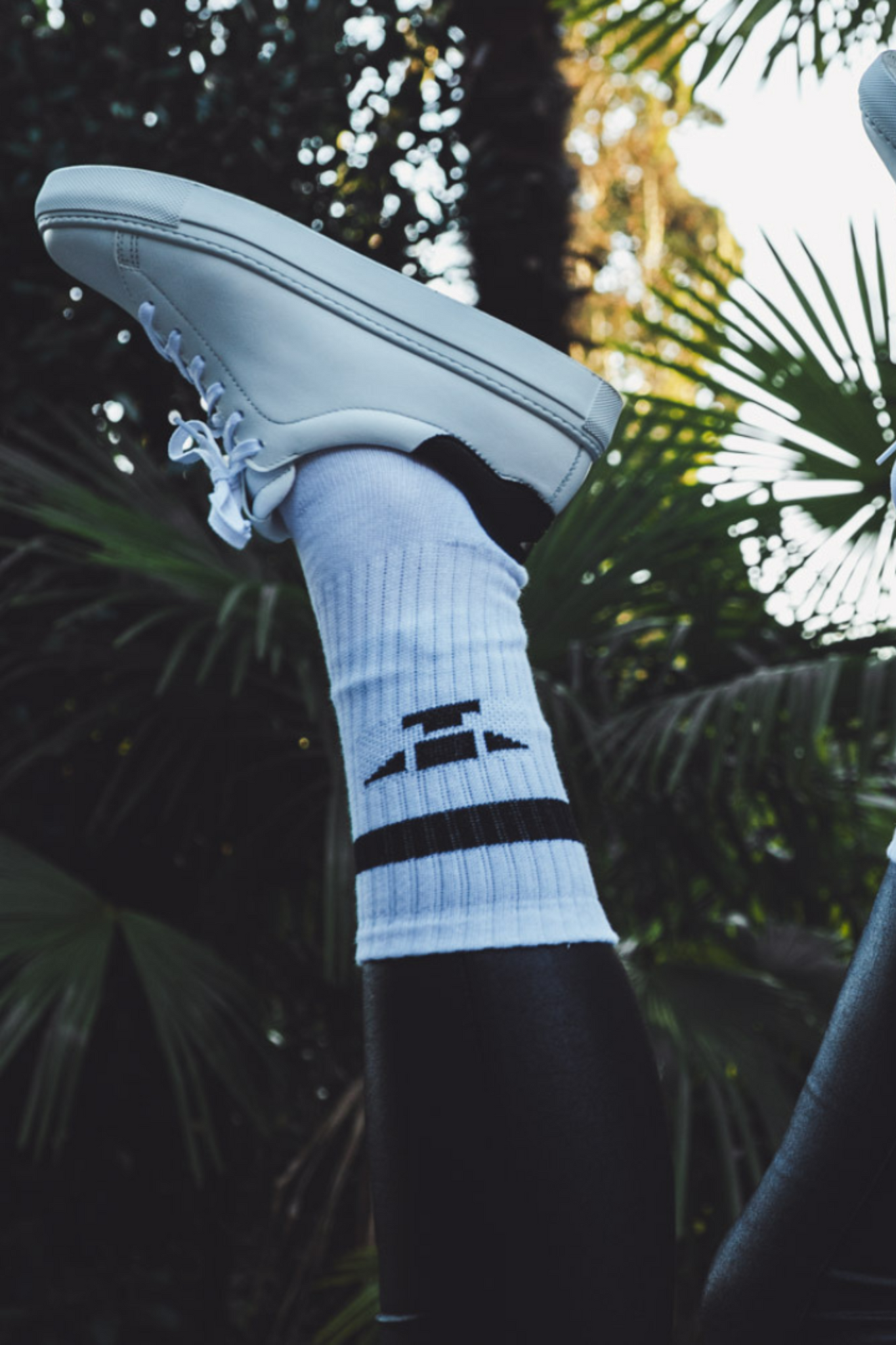Tiefer, weisser Leder-Sneaker Unisex, mit dezenten goldenen Details, weisse Baumwoll-Socken mit schwarzem Amboss