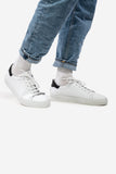 Weisser, tiefer Unisex-Sneaker aus Leder, schwarze Fersenpartie, kombiniert mit Jeans und weissen Freizeit Socken